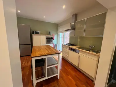 a kitchen with white cabinets and a wooden counter top at Cottage CaLoMa in Eupen