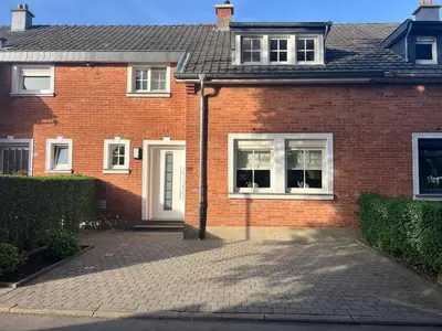 a brick house with white windows and a driveway at Cottage CaLoMa in Eupen