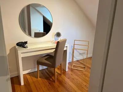 a white desk with a mirror and a chair at Cottage CaLoMa in Eupen
