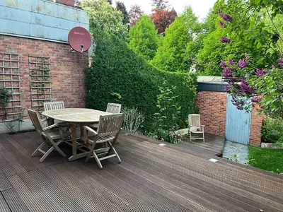 a wooden table and chairs on a wooden deck at Cottage CaLoMa in Eupen