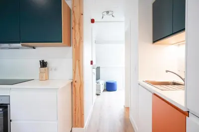 a kitchen with white cabinets and an open door at Gîte d'artiste, Riverside in Tilff