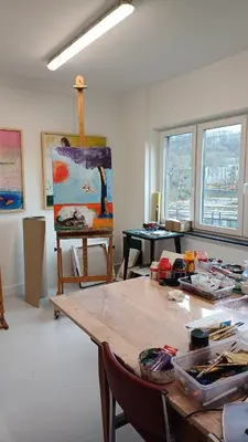 a room with a wooden table and a painting at Gîte d'artiste, Riverside in Tilff