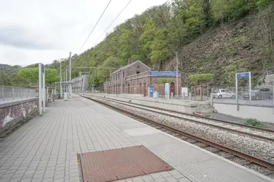 a train station with a platform and train tracks at Gîte d'artiste, Riverside in Tilff