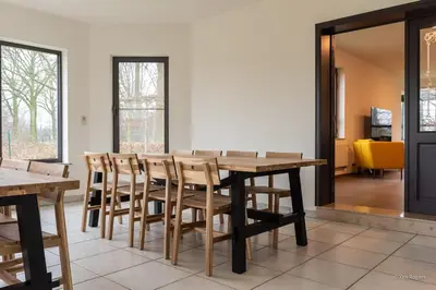 a conference room with a wooden table and chairs at 14 beds, 20p, 2 bath-, 1 livingroom in Houthalen-Helchteren