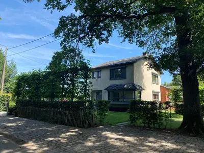 a house with a fence and a tree at 14 beds, 20p, 2 bath-, 1 livingroom in Houthalen-Helchteren