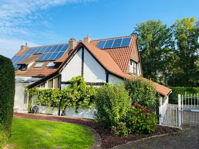 a house with solar panels on the roof at Luxe Vacation Villa with swimming pool, 5 bedrooms in Houthalen-Helchteren