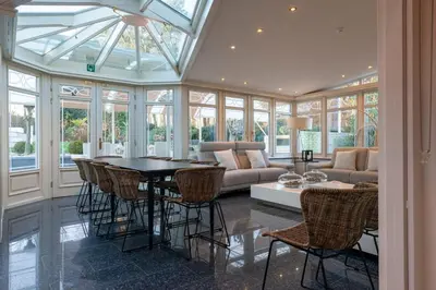 a living room with a couch and a table and chairs at Luxe Vacation Villa with swimming pool, 5 bedrooms in Houthalen-Helchteren