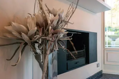 a vase filled with flowers in front of a tv at Luxe Vacation Villa with swimming pool, 5 bedrooms in Houthalen-Helchteren