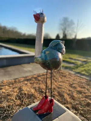 a statue of a statue of a bird with red shoes at Het Kabinet in Munsterbilzen