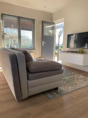 a living room with a couch and a tv at Het Kabinet in Munsterbilzen