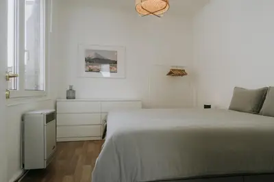 a white bedroom with a large bed and a window at 1 bedroom apartment in Liège center, Place du Marche - 3rd floor in Liège