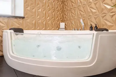 a bath tub with a sink in a bathroom at LoveRoom avec balnéo privative in Flémalle-Grande