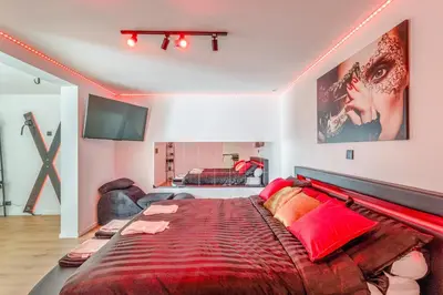 a bedroom with a large bed with a red blanket at LoveRoom avec balnéo privative in Flémalle-Grande