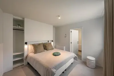 a bedroom with a bed with a white wall at Borgraaf - Fruitzicht in Borgloon