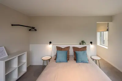 a bedroom with a large bed with blue pillows at Borgraaf - Fruitzicht in Borgloon