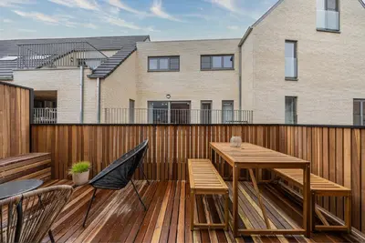 a wooden deck with a wooden table and chairs at Borgraaf - Fruitzicht in Borgloon