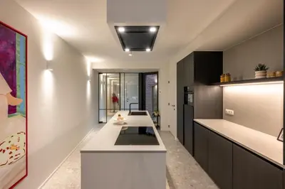 a kitchen with a white island in a room at Borgraaf - Palazzio in Borgloon
