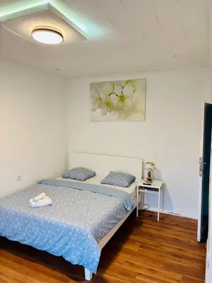 a bedroom with a bed and a table with a lamp at 3 Bedrooms budget appartement in Heers