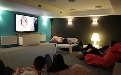 a group of people sitting in a room watching a tv at Le spot Central securisé sauna rooftop in Liège