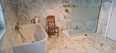 a bathroom with a tub and a chair and a mirror at Basecamp18 in Lommel
