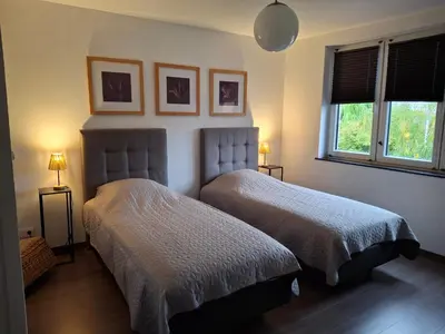 a bedroom with two beds and two lamps and a window at Bizette67 in Herstal