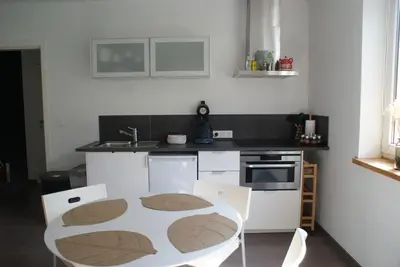 a kitchen with a table and chairs in it at Bizette67 in Herstal