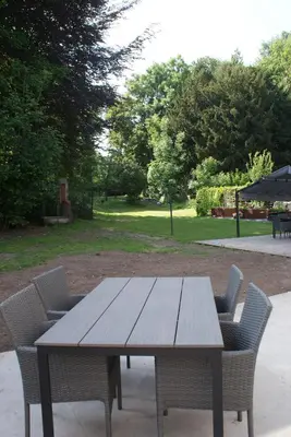 a wooden table with chairs around it in a park at Bizette67 in Herstal