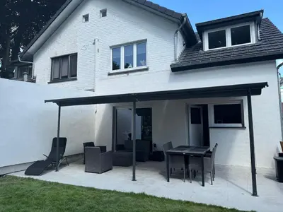 a patio with a table and chairs in front of a house at Bizette67 in Herstal