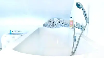 a white bath tub with a shower in a bathroom at BEEEP Stay in Hasselt
