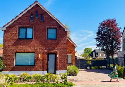 a young girl walking past a brick house at BEEEP Stay in Hasselt