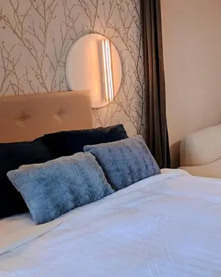 a bed with two blue pillows on top of it at Studio Eik 105 at the pool in nature domain in Houthalen-Helchteren