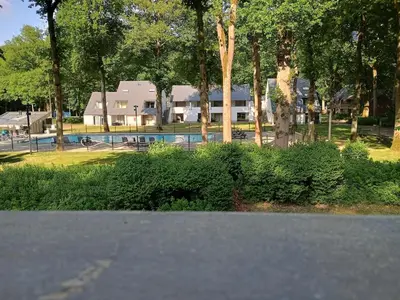 a house with a swimming pool in a park at Studio Eik 105 at the pool in nature domain in Houthalen-Helchteren