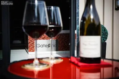 two wine glasses sitting on a table with a bottle of wine at Le Gate One in Herbesthal