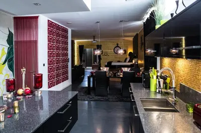 a kitchen with black counter tops and a living room at Le Gate One in Herbesthal