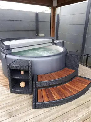 a hot tub sitting on top of a wooden deck at Le Gate One in Herbesthal