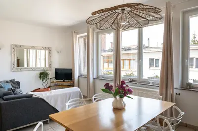 a living room with a table and a couch at Chez Marraine Suzanne in Liège