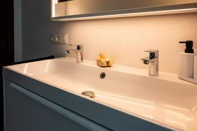 a white sink in a bathroom with a mirror at Chez Marraine Suzanne in Liège