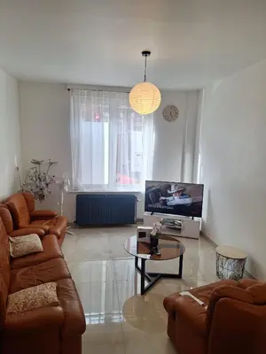 a living room with a couch and a tv at Maison sympa in Liège