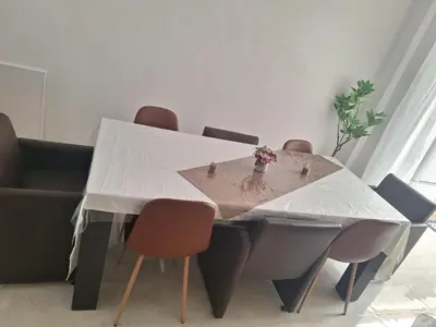 a dining room table with a white table and chairs at Maison sympa in Liège