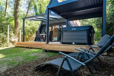 a couple of chairs sitting in front of a tiny house at Boshuisje met jacuzzi in Lanaken