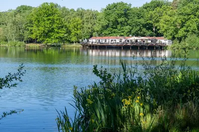 a view of a lake with a house on a dock at Boshuisje met jacuzzi in Lanaken