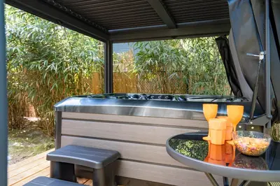 a sauna with a table and a bath tub at Boshuisje met jacuzzi in Lanaken