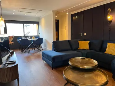 a living room with a blue couch and a table at Garden Street - Antiquity Blue in Lommel
