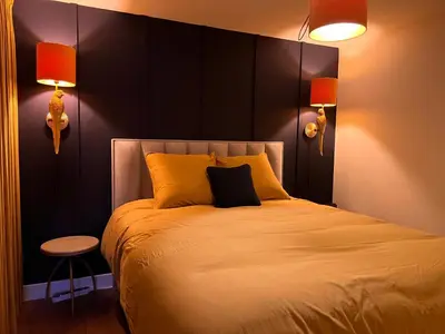 a bedroom with a large bed with two lamps and a stool at Garden Street - Antiquity Blue in Lommel