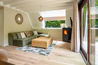 a living room with a couch and a table at Boshuisje Rekem - Kitoko in Lanaken