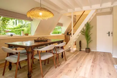 a dining room with a wooden table and chairs at Boshuisje Rekem - Kitoko in Lanaken