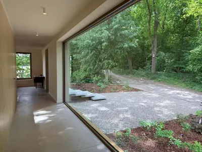 a room with a large window looking out at a yard at Zandberg11 in Bree