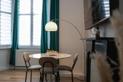 a dining room with a table with chairs and a lamp at Cozy Home Liege in Liège