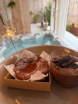 a box of donuts sitting on a table with a candle at Wellness B&B Essential by Cin in Zonhoven