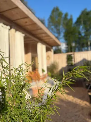 a bush in front of a building with columns at Wellness B&B Essential by Cin in Zonhoven